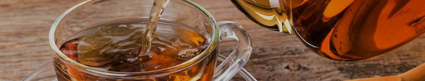 Tea Being Poured into Glass Mug